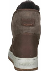 Braune Wildleder-Stiefeletten mit einer strukturierten Oberfläche, gepolstertem Schaft und weißer Gummisohle. Markenlogo auf der Rückseite sichtbar.