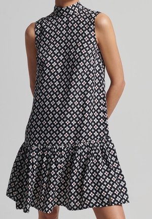 Ärmelloses schwarzes Kleid mit hohem Kragen und ausgestelltem Saum, gemustert mit kleinen weißen und roten geometrischen Formen.