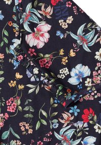 Tela oscura con estampado floral colorido que incluye lirios, margaritas y pequeñas flores, mostrando un detalle de costura fruncida.