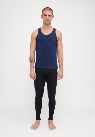 Mørkeblå tanktop med rund hals og logodetaljer, kombinert med svarte tettsittende leggings laget av glatt, elastisk stoff.