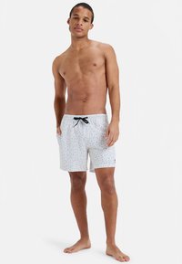 Vyriški maudymosi šortai balti su margais taškeliais, turi elastingą juosmenį ir juodą raištelį. Lengva medžiaga, laisvo modelio.