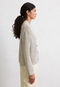Light gray knit cardigan with a textured pattern, featuring a button front and ribbed cuffs, paired with a cream-colored bottom.