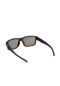 Lunettes de sport noires enveloppantes avec des verres rectangulaires foncés et un logo orange sur la branche latérale.