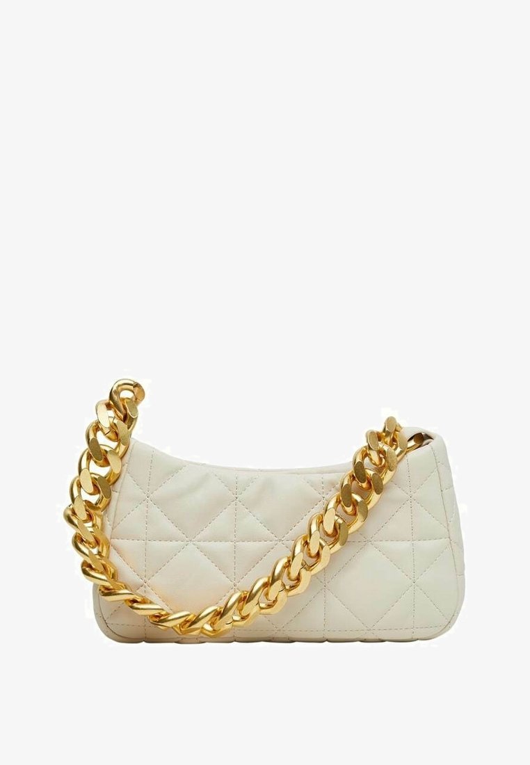 Sac à main matelassé crème avec une grande lanière en chaîne dorée brillante, présenté sur fond blanc.