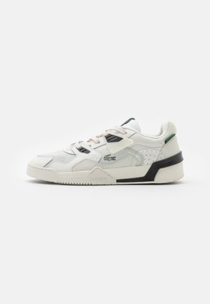Zapatilla blanca de cuero con paneles de malla, acentos negros en la suela, cordones rosas y un logo verde. Presenta un diseño retro y una superficie texturizada.