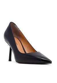 Pump nera in pelle con tacco alto, punta affilata, dettaglio lucido nero sulla punta e tacco a stiletto elegante. Texture liscia con interno beige.