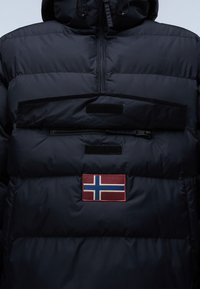 Giacca puffer blu navy con cappuccio, tasca frontale con zip e una patch ricamata della bandiera norvegese sul petto. Materiale resistente e trapuntato.