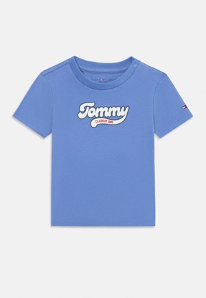 Lysblå bomulds t-shirt med korte ærmer, prydet med et hvidt broderet "Tommy" logo og "CLASS OF 1985" nedenfor, rund halsudskæring, uden mønster.
