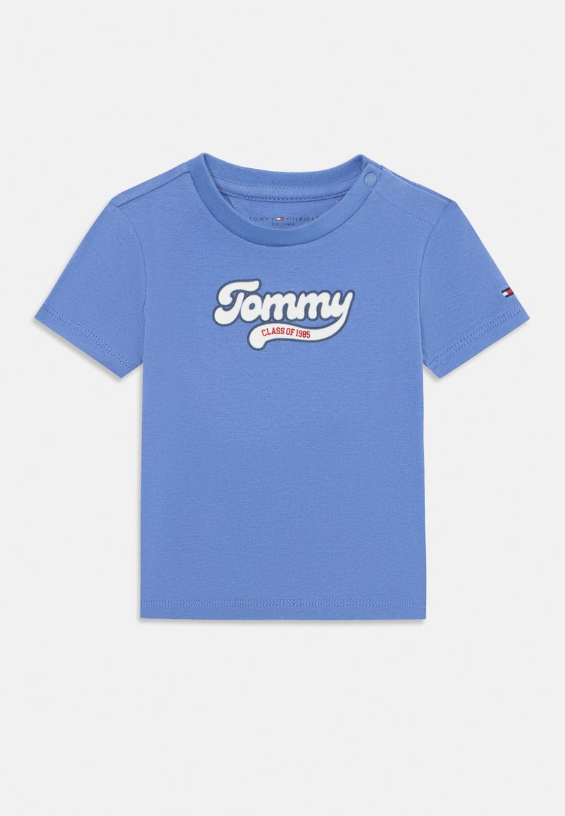 Lyseblå bomulls t-skjorte med korte ermer, som har et hvitt brodert "Tommy"-logo og "CLASS OF 1985" under, rund halslinning, uten mønster.
