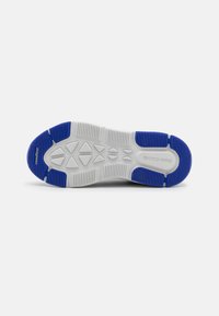 Weiße Sneakersohle mit strukturiertem grauem und blauem Gummi. Verfügt über Profilmuster und das eingestempelte "SKECHERS"-Logo auf der Oberfläche.