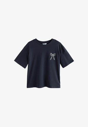 Camiseta de manga corta azul marino con cuello redondo y un pequeño diseño de lazo blanco en el lado izquierdo del pecho.
