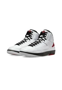 Höga sneakers med ett ovandel i vit läder, svarta snörningar, svart gummisula och röda detaljer vid hälen och plösen. Perforerade detaljer finns.