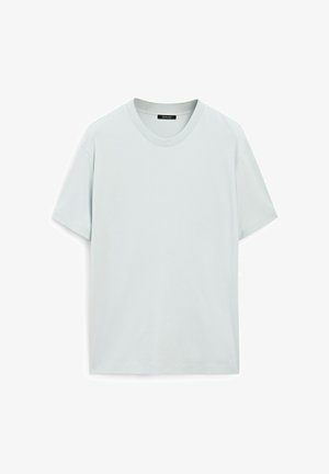 Světle modré tričko s krátkým rukávem vyrobené z měkké látky. Má kulatý výstřih a volný střih. Hladká textura bez viditelných vzorů nebo grafik.