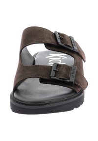 Sandalo scivoloso in suede marrone con due fibbie nere regolabili, suola nera strutturata e logo Kickers sulla soletta. Design piatto.