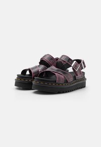 Black sandals with pink accents, featuring a chunky platform and open-toe design. Adjustable straps and textured sole for grip.