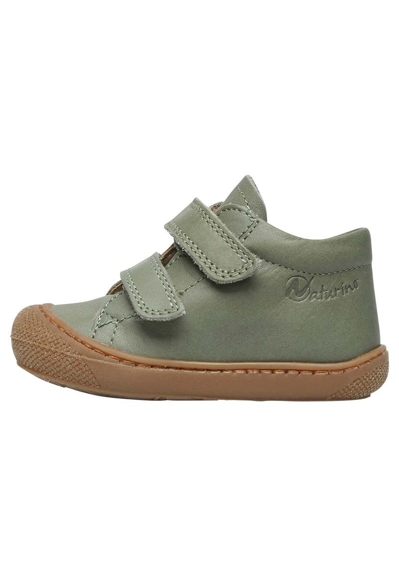 Scarpa per bambini in pelle verde con due cinturini in velcro e una suola in gomma marrone. Presenta una punta testurizzata e accenti cuciti.