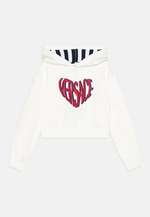 Kuttet hvit hettegenser med en rød og blå brodert "VERSACE" hjerte logo, med stripete svart og hvit hetteforing. Mykt stoff.