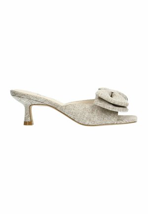 Beige hoge muiltjes met een open teen en een textiel bovenwerk. Kenmerkt een grote decoratieve strik op de band en een kleine, taps toelopende hak.