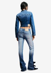 Tumedas sinise tooniga lühendatud teksajakk, mis on kombineeritud hele siniste laiade alt hõrenevate teksapükstega, millel on gradientvärvusefekt, mõlemal taskud ja õmblused.