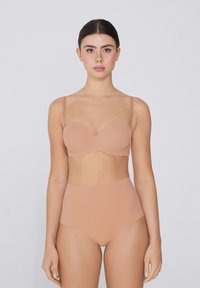 Hladká bezramínková podprsenka s tvarovanými poháry a vysokými kalhotkami. Oba kousky jsou vyrobeny z matného materiálu a mají bezešvý design.