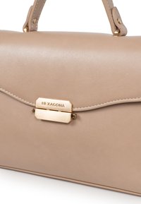 Borsa in pelle beige con una texture liscia, dotata di una chiusura dorata con la scritta "HEXAGONA" incisa e manici corti per il trasporto.