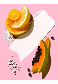 Tranches d'agrumes et de papaye avec des graines sur un fond rose, accompagnées de crème blanche et de petites billes blanches.