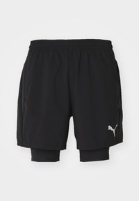 Zwarte sportshorts met geïntegreerde binnenlaag, elastische tailleband, zijzakken en een zilveren Puma-logo op de linkeronderzijde.