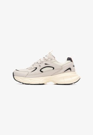Zapatilla gris claro con material de malla y sintético, punta redondeada, acentos en negro contrastantes, suela gruesa de color crema y cierre de cordones.