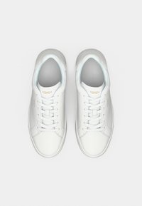 Λευκά δερμάτινα αθλητικά παπούτσια με ομαλή υφή και ανοιχτό μπλε λεπτομέρειες. Σύστημα κορδονιών μπροστά και ανάγλυφο λογότυπο της μάρκας στη γλώσσα.