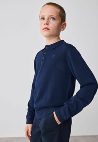 Navy niebieski sweterek polo z długim rękawem, wykonany z dzianiny. Posiada kołnierzyk, listwę z guzikami oraz haftowane logo na piersi.