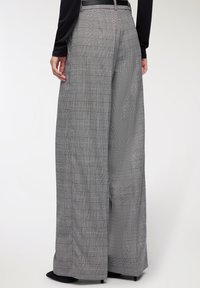 Szerokie spodni z szarym kratkowanym wzorem, w wysokim stanie, wykonane z miękkiego materiału, z delikatnym wzorem kraty, wykończone eleganckim czarnym paskiem.