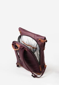Zaino bordeaux con dettagli in pelle beige, dotato di una cerniera superiore, spallacci imbottiti e un interno in tessuto a quadri. Aperto per mostrare la visibilità dei compartimenti.