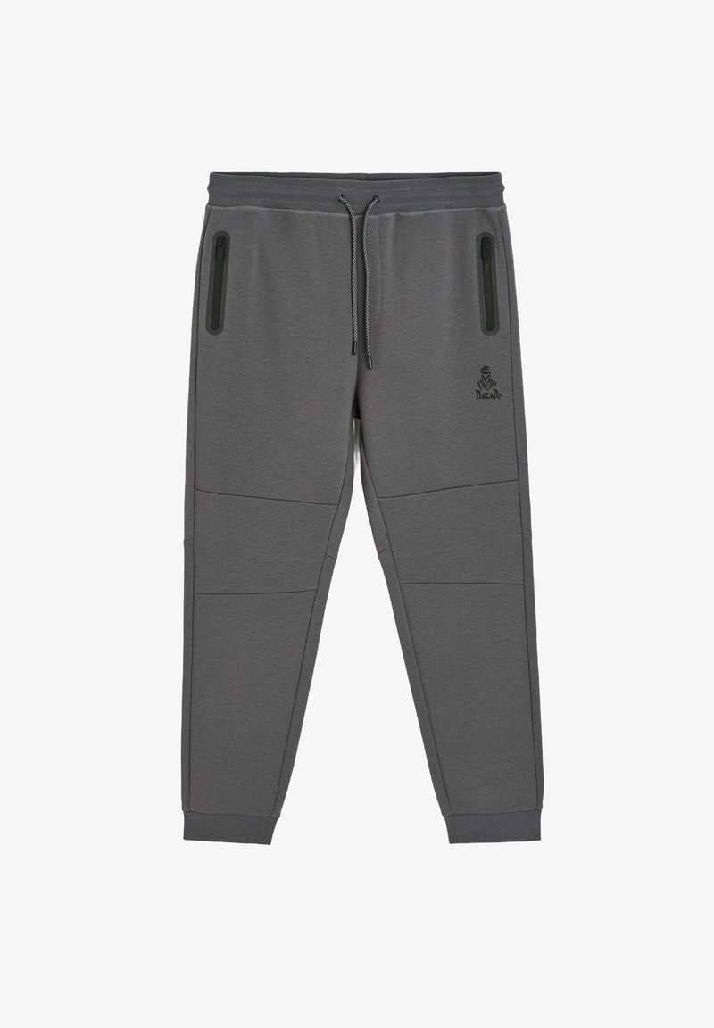 Szare spodnie sportowe o tapered fit, z dwiema kieszeniami na zamek i ściągaczami przy kostkach. Posiadają przeszywane panele oraz logo na biodrze.