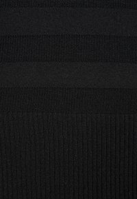 Tissu noir avec des rayures horizontales texturées alternant entre des motifs de tricot lisse et côtelé.