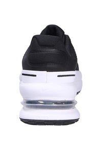 Sneaker nera con una toma in rete e una suola intermedia bianca. Presenta un'unità air visibile, un tallone texturizzato e accenti minimi.