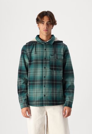 Green and black plaid shirt jacket with buttons, hood, and front pocket. Soft material with a textured finish and contrasting hood lining.