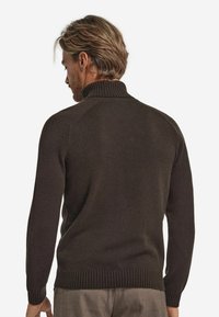 Dunkelbrauner Strickpullover mit hohem Kragen, gerippten Ärmeln und Saum. Hat eine glatte Textur und Raglanärmel, von hinten gesehen.
