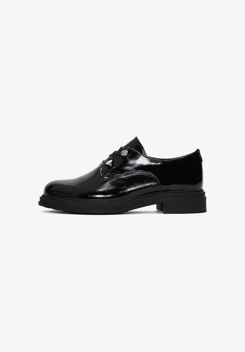 Des chaussures en cuir verni noir avec un bout arrondi, un système de laçage, des éléments décoratifs en métal et une semelle en caoutchouc épaisse et basse. Texture lisse et lignes épurées.