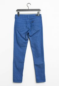 Blauwe denim skinny jeans met een gladde textuur, met twee achterzakken en een middelhoge taille, hangend aan een zwarte plastic hanger.