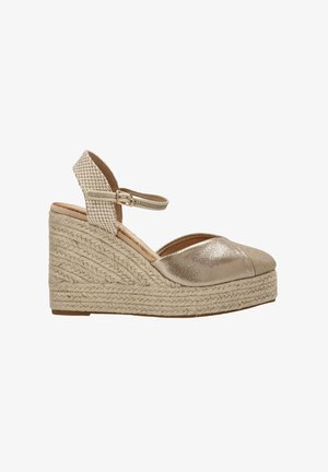 Espadrilles de cuña con parte superior de cuero dorado metálico y suela de yute trenzado. Cuenta con una correa en el tobillo a rayas para un ajuste seguro y estabilidad.