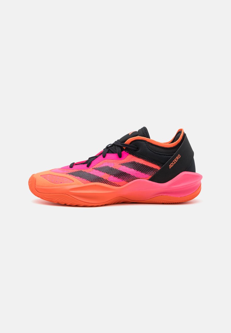 Scarpe sportive con una tomaia nera, design in mesh rosa e arancione e suola in gomma testurizzata. Un distintivo motivo a tre strisce adorna il lato.