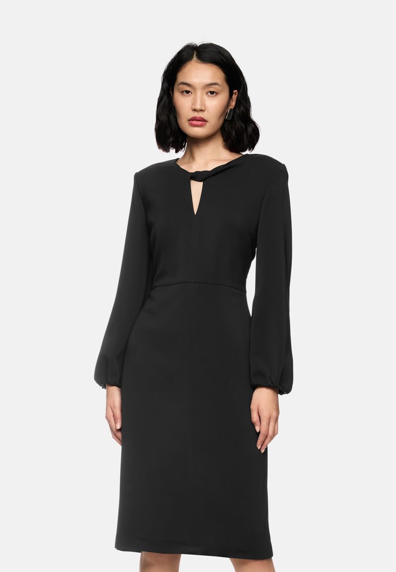 Schwarzes Kleid mit langen Puffärmeln, einem Schlüssellochausschnitt und glatter Textur. Das mittellange Design hat eine taillierte Silhouette und subtile Nahtdetails.
