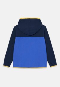 Sweat à capuche avec un design en blocs de couleurs bleu et marine, agrémenté d'accents jaunes le long de la capuche et de l'ourlet, fabriqué en tissu doux.