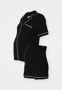 Sorte graviditetspysjamas med kort erm, med hvite pipingdetaljer. Inkluderer en knappened skjorte og justerbare shorts. Mykt materiale.