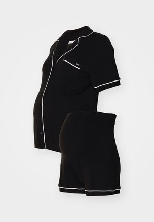 Schwarze Mutterschaftsschlafanzüge mit kurzen Ärmeln, ausgestattet mit weißen Paspeldetails. Enthält ein kurzärmliges Hemd und verstellbare Shorts. Hergestellt aus weichem Material.