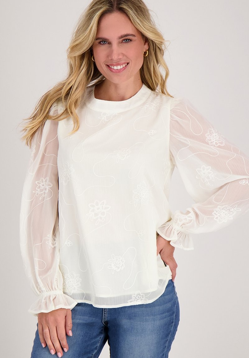 Witte blouse met sheer, geplooide lange mouwen, geborduurde bloemenpatronen en elastische boorden. Gladde textuur en ronde halslijn.