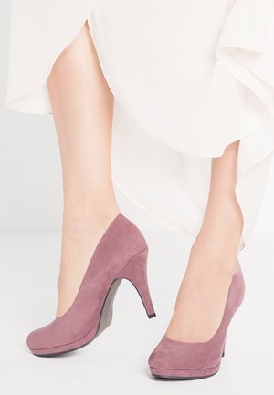 Chaussures à talons hauts en daim violet avec un bout rond et une plateforme surélevée ; présentent une texture lisse et un design de talon incurvé.