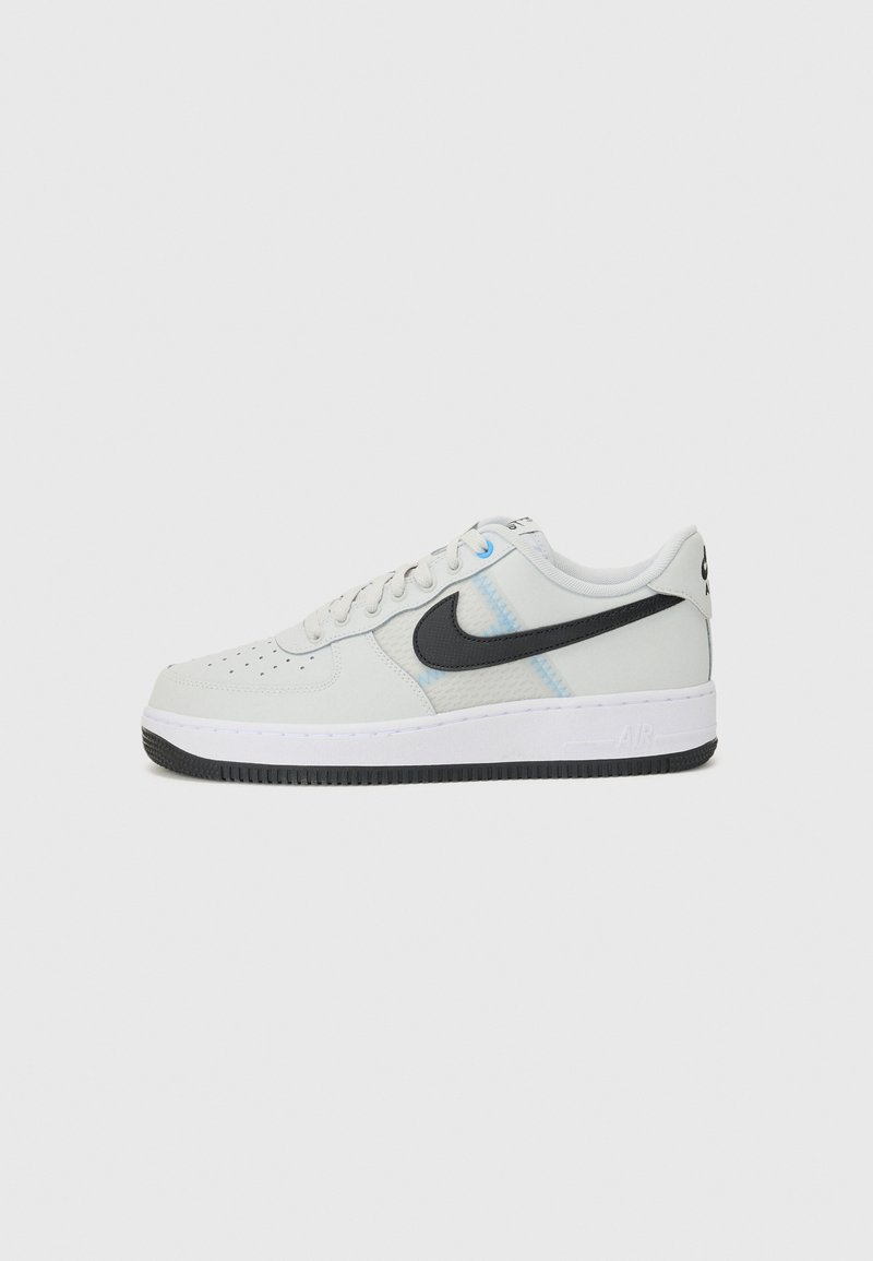 Nike Air Force 1 sneakers, featuring a white leather upper with black accents, light blue stitching, and a textured rubber sole.