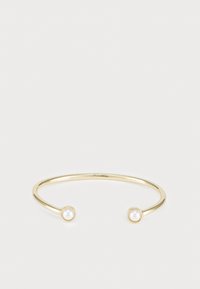 Bracelet jonc doré avec une finition métallique lisse, comportant deux petites perles rondes blanches à chaque extrémité.