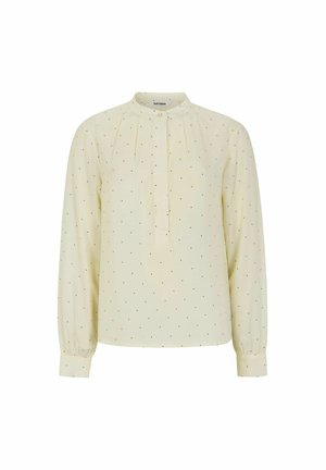 Light yellow blouse with long sleeves, pleated front, mandarin collar, and black dotted pattern throughout. Soft, smooth fabric texture.